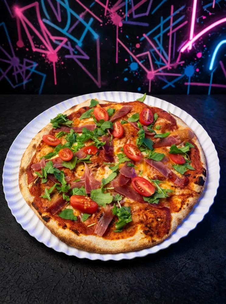 Pizza de jamón serrano, rúcula y tomates cherry